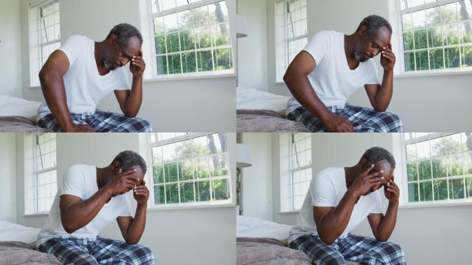 患有头痛的老年非洲裔美国人坐在床上，抱着头