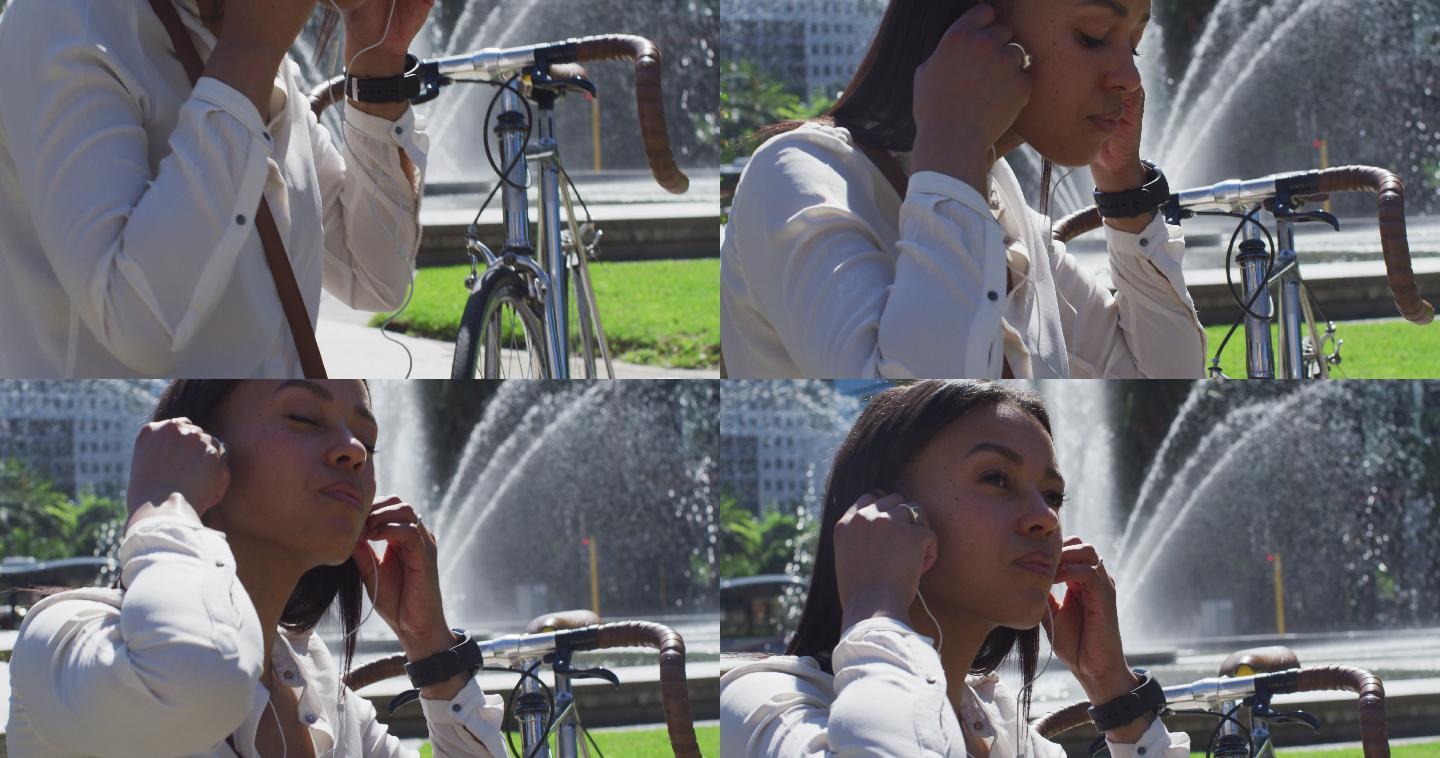 非裔美国妇女骑自行车戴耳机在城市公园