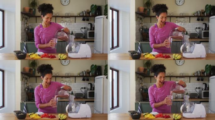 这是一幅混血妇女的肖像，她在家里的厨房里从果汁机里往玻璃杯里倒果汁