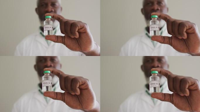 男性非洲裔美国医生拿着疫苗瓶在医院的近距离观察