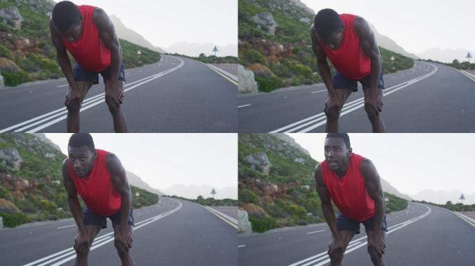 一个非裔美国人在山路上锻炼，在跑步过程中停下来休息