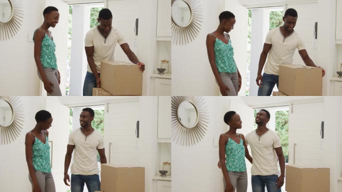 快乐的非裔美国夫妇在屋里整理包装盒，拥抱在一起