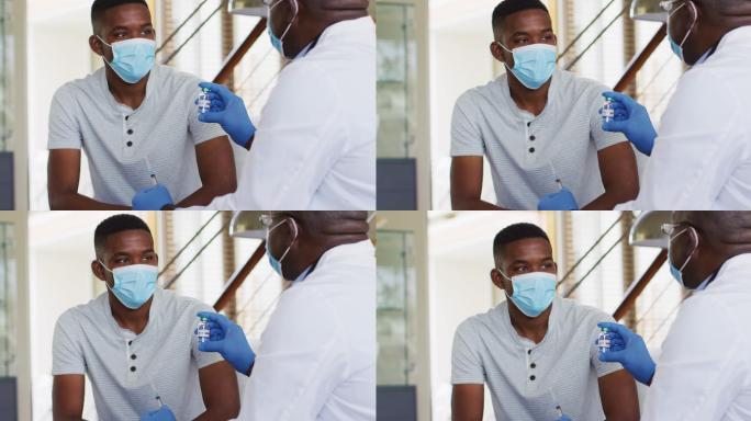 非裔美国资深男医生戴着口罩在家给男患者注射新冠疫苗