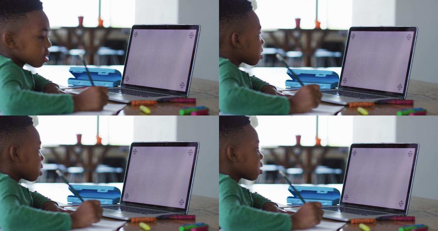一个非洲裔美国男孩在家里做作业的时候，用笔记本电脑打视频电话