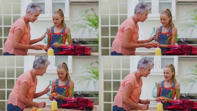 白人祖母在厨房准备盒饭和孙女聊天给她水果