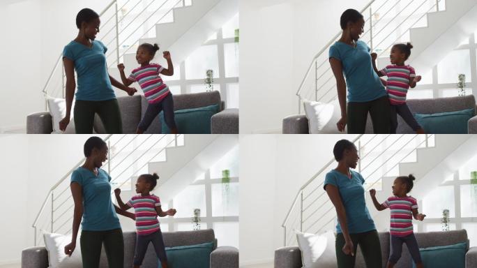 快乐的非裔美国母亲和女儿在家里跳舞和玩得开心