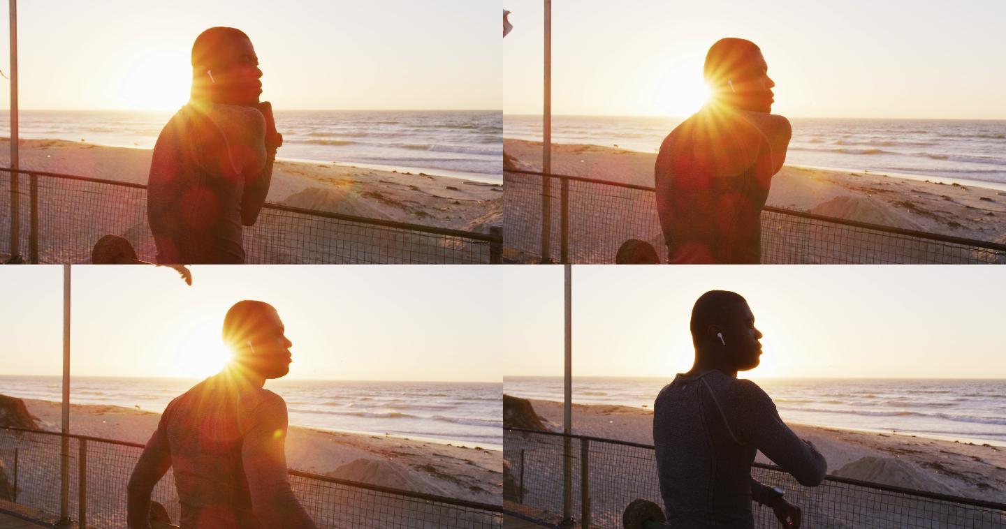专注的非裔美国人在日落时分在海边伸展运动