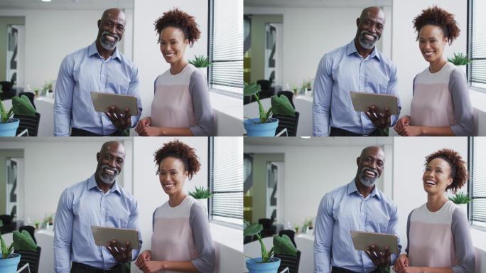 微笑的商人和女商人的肖像，男人拿着数字平板电脑