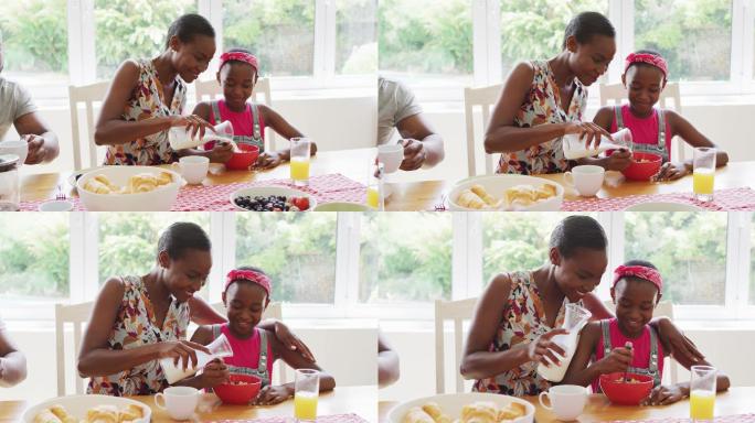 非裔美国母亲往女儿家里的麦片碗里倒牛奶