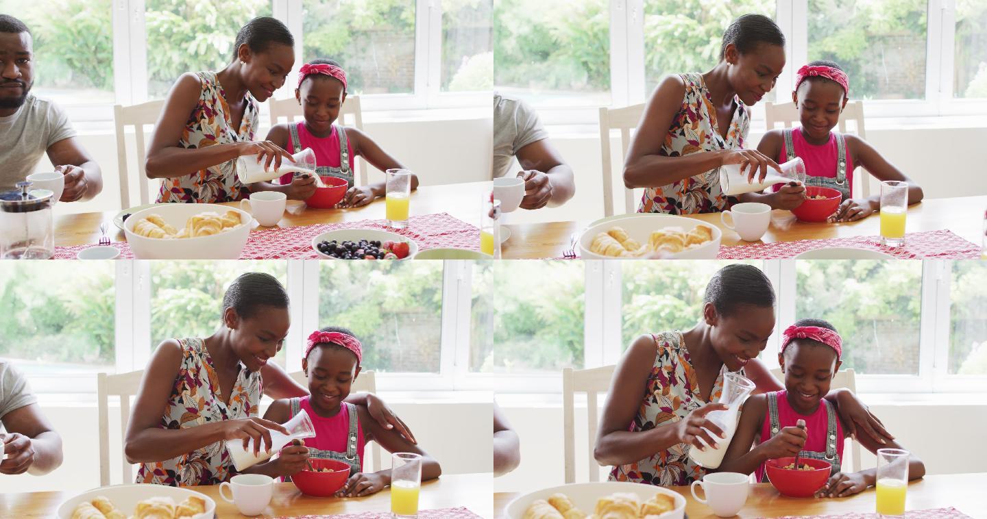 非裔美国母亲往女儿家里的麦片碗里倒牛奶