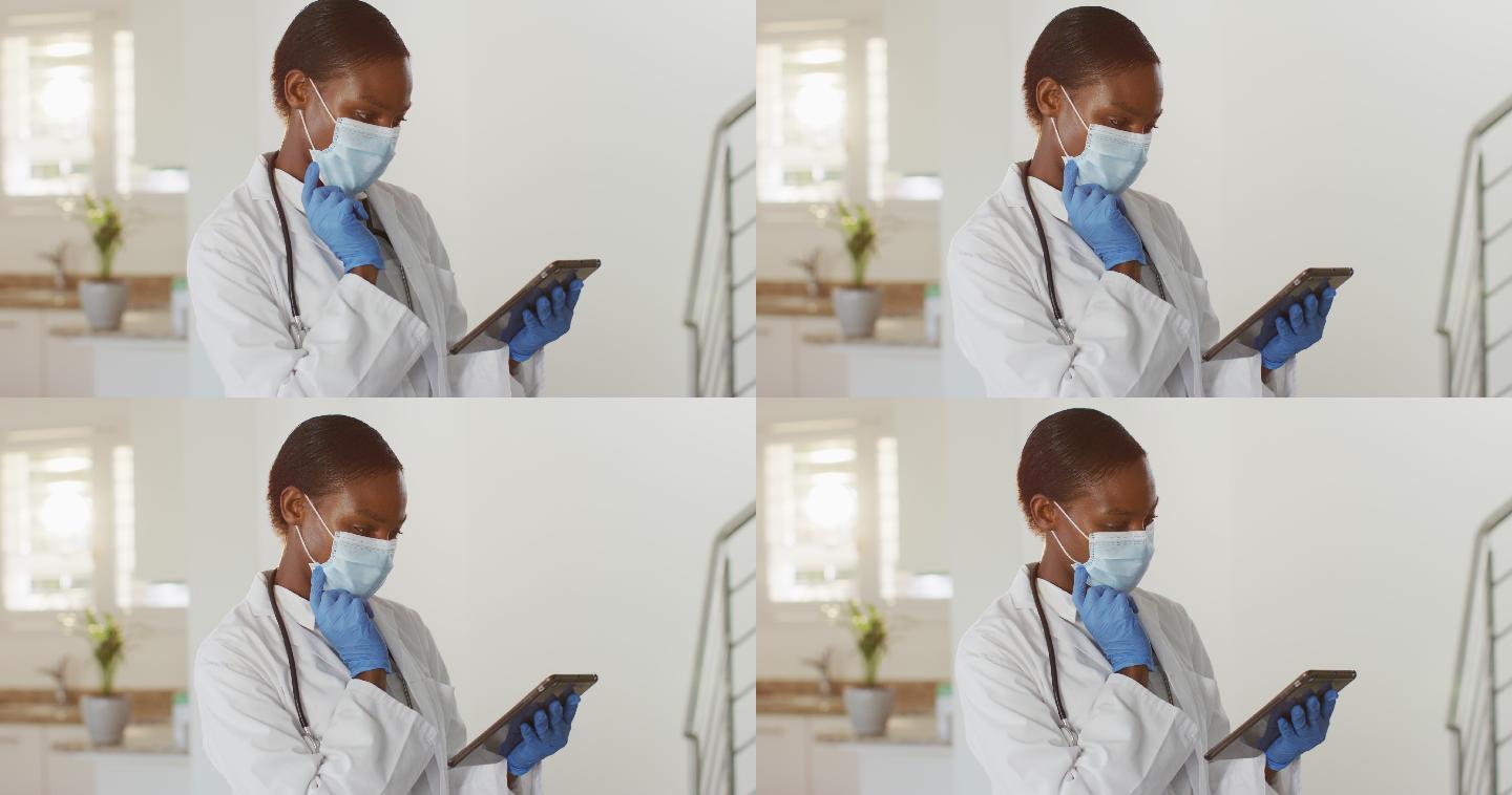 非裔美国女医生戴着口罩，使用数码平板进行视频电话咨询