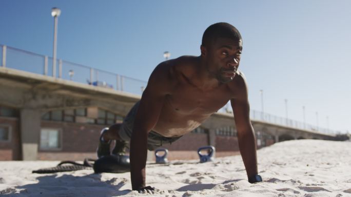 非裔美国人做俯卧撑，在海滩上做户外运动
