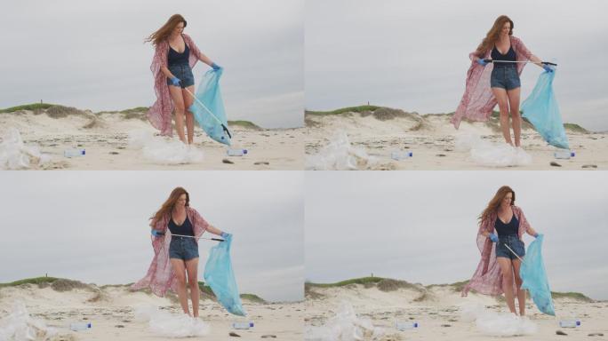 戴着乳胶手套的白人妇女用抓棍从海滩上收集垃圾