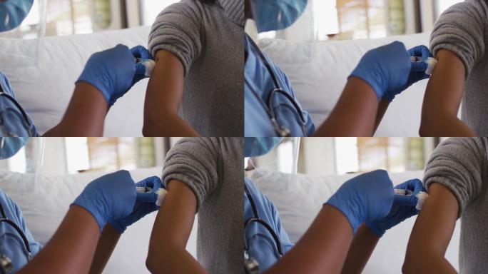 非裔美国女医生戴着口罩给非裔美国病人接种疫苗