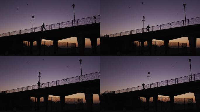 傍晚在桥上奔跑的人的剪影