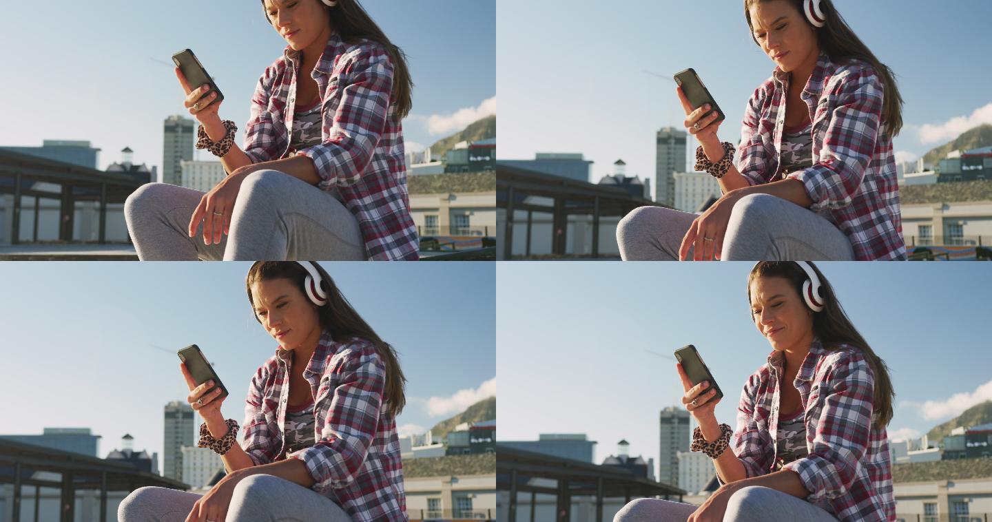一个带着耳机在滑板场玩智能手机的白人女人