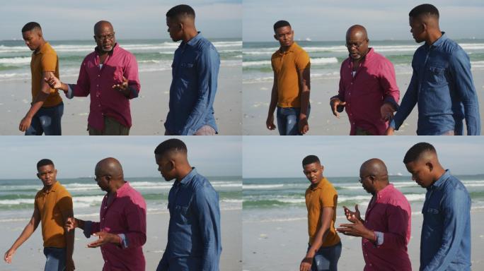 一位非洲裔美国老人和一对十几岁的儿子在海滩上散步聊天