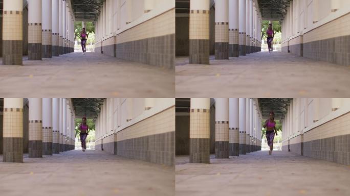 非裔美国妇女戴着耳机在走廊里奔跑