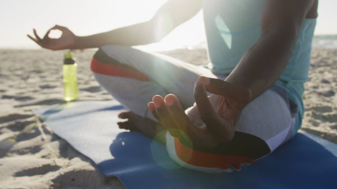 非裔美国人在海滩上练习瑜伽，在海边户外锻炼