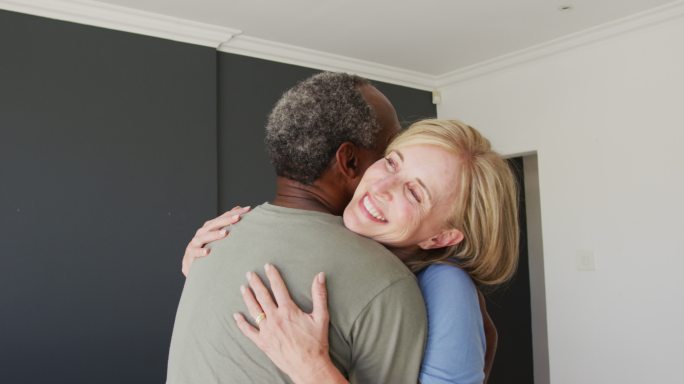 混合种族的老年夫妇在家里互相拥抱