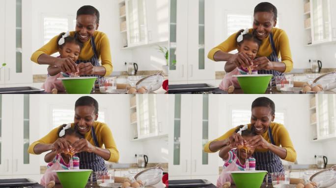 快乐的非裔美国母女穿着围裙在厨房做饭