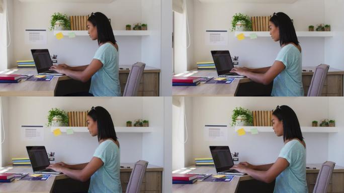 不同种族、不同性别的人坐在办公桌前使用笔记本电脑在家工作