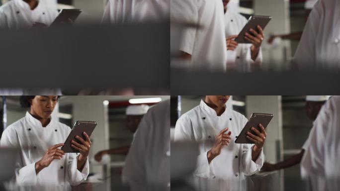 非裔美国女厨师在餐厅厨房使用平板电脑