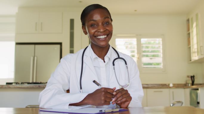 非洲裔快乐的美国女医生在视频电话咨询中挥手
