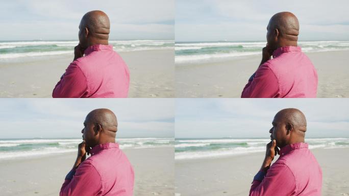 一个非裔美国人，在沙滩上沉思着，看着大海