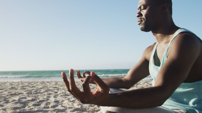非裔美国人在海滩上练习瑜伽，在海边做户外运动