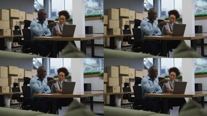 各种各样的男性和女性商务同事在办公室聊天和使用笔记本电脑