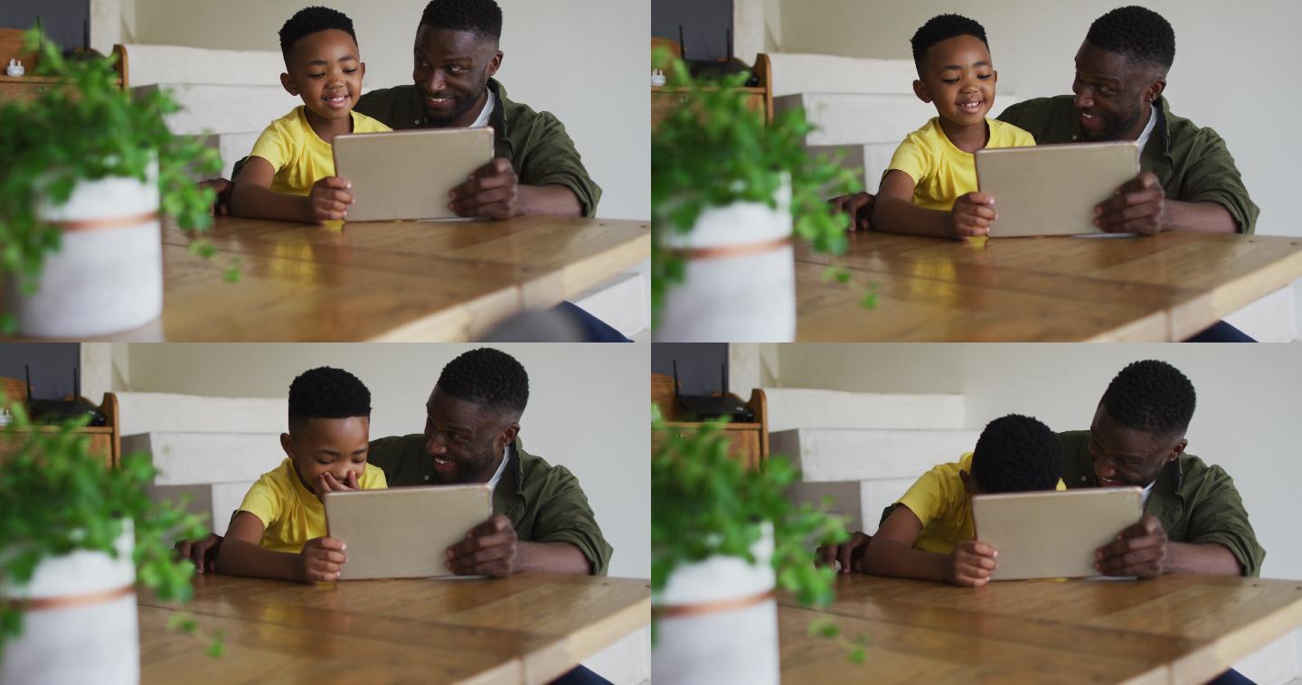 非裔美国人父亲和儿子一起使用数码平板电脑