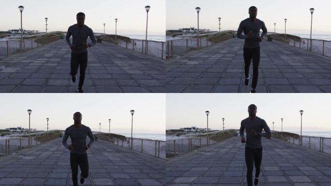 专注的非裔美国人在户外锻炼，在海边跑步