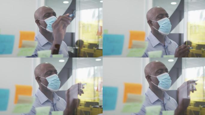 非裔美国商人戴着面具头脑风暴，在办公室用便笺写板书