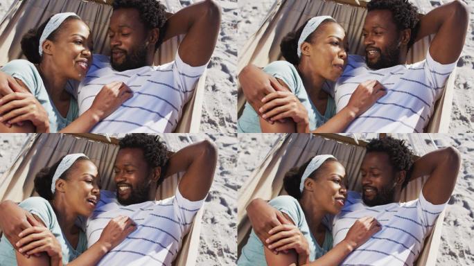 一对非洲裔美国夫妇一起躺在沙滩上的吊床上