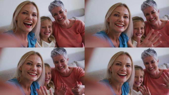 白人奶奶、母亲和女儿在家里用智能手机视频通话时挥手致意