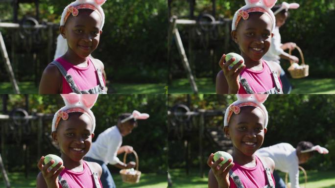 非裔美国女孩戴着复活节兔子耳朵和哥哥在花园里寻找复活节彩蛋