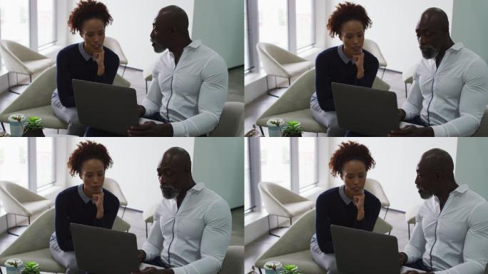 不同性别的商务同事交谈，男人在办公室使用笔记本电脑