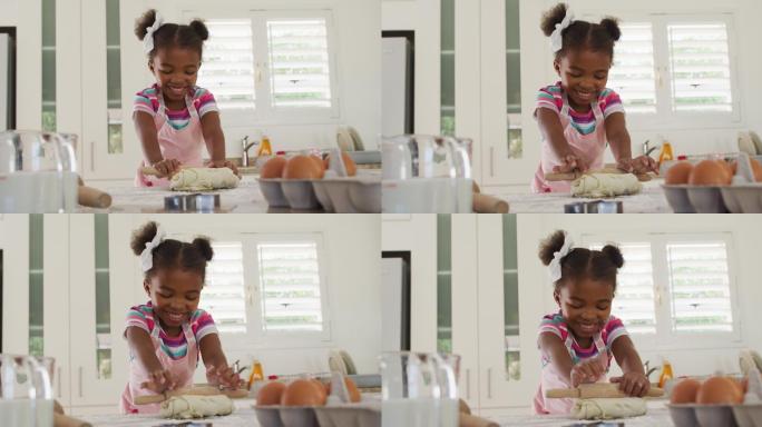 快乐的非洲裔美国女孩在厨房里揉面团