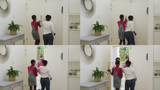 非裔美国兄弟姐妹戴着口罩在门口问候祖父母