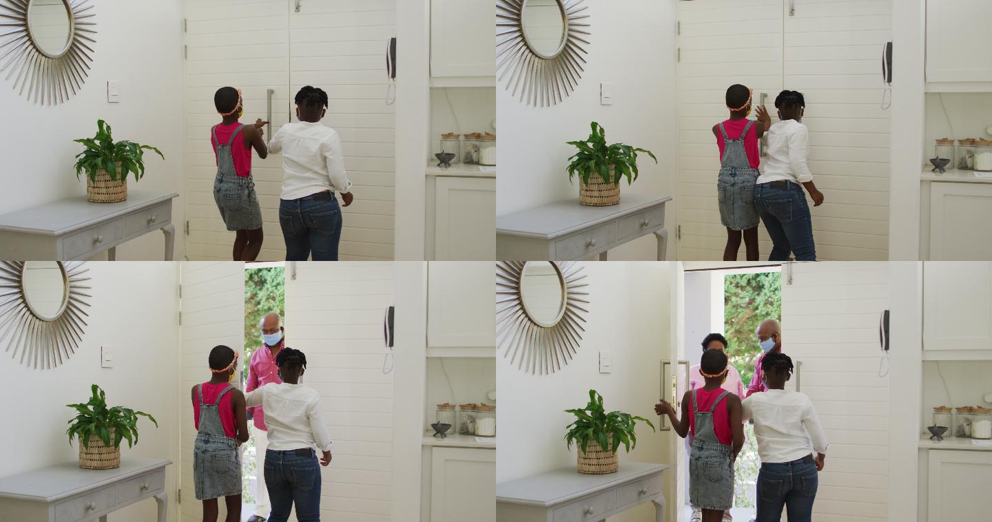 非裔美国兄弟姐妹戴着口罩在门口问候祖父母