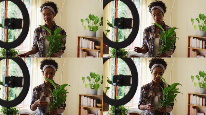 混血女视频博主在花盆里移植植物，并在家里用智能手机录制