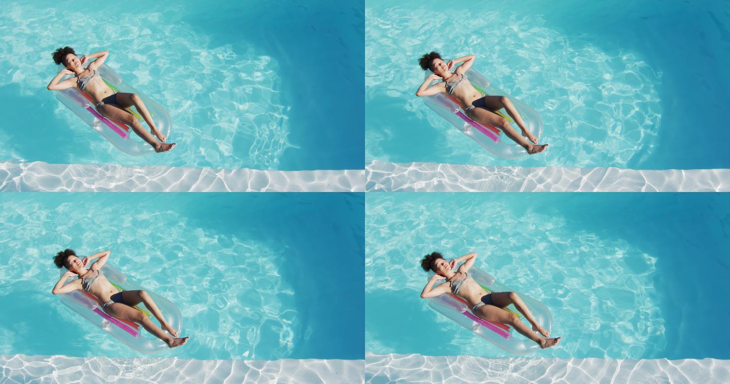 混合种族妇女有乐趣日光浴充气游泳池