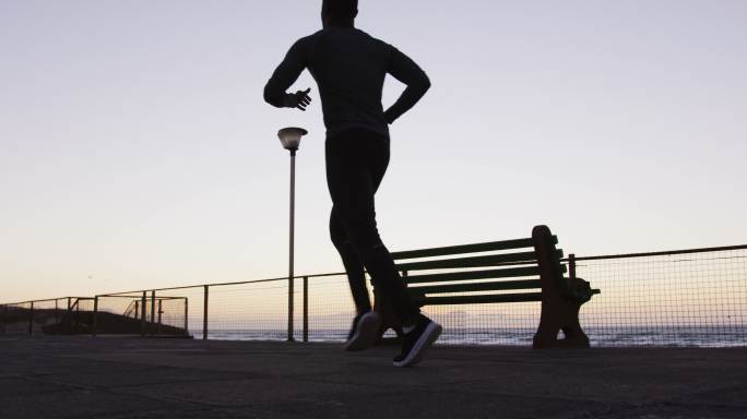 非裔美国人在户外锻炼，晚上在海边跑步