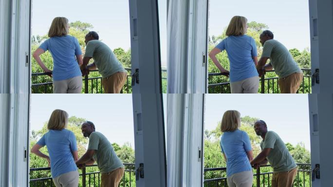 一对跨种族的老年夫妇站在家里的阳台上聊天