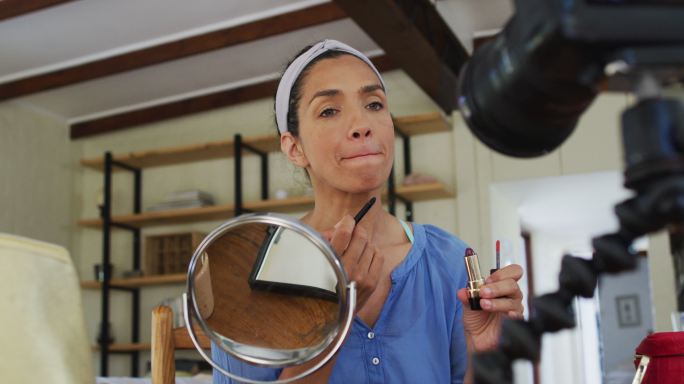 混血女视频博主在家化妆并在数码相机上录音