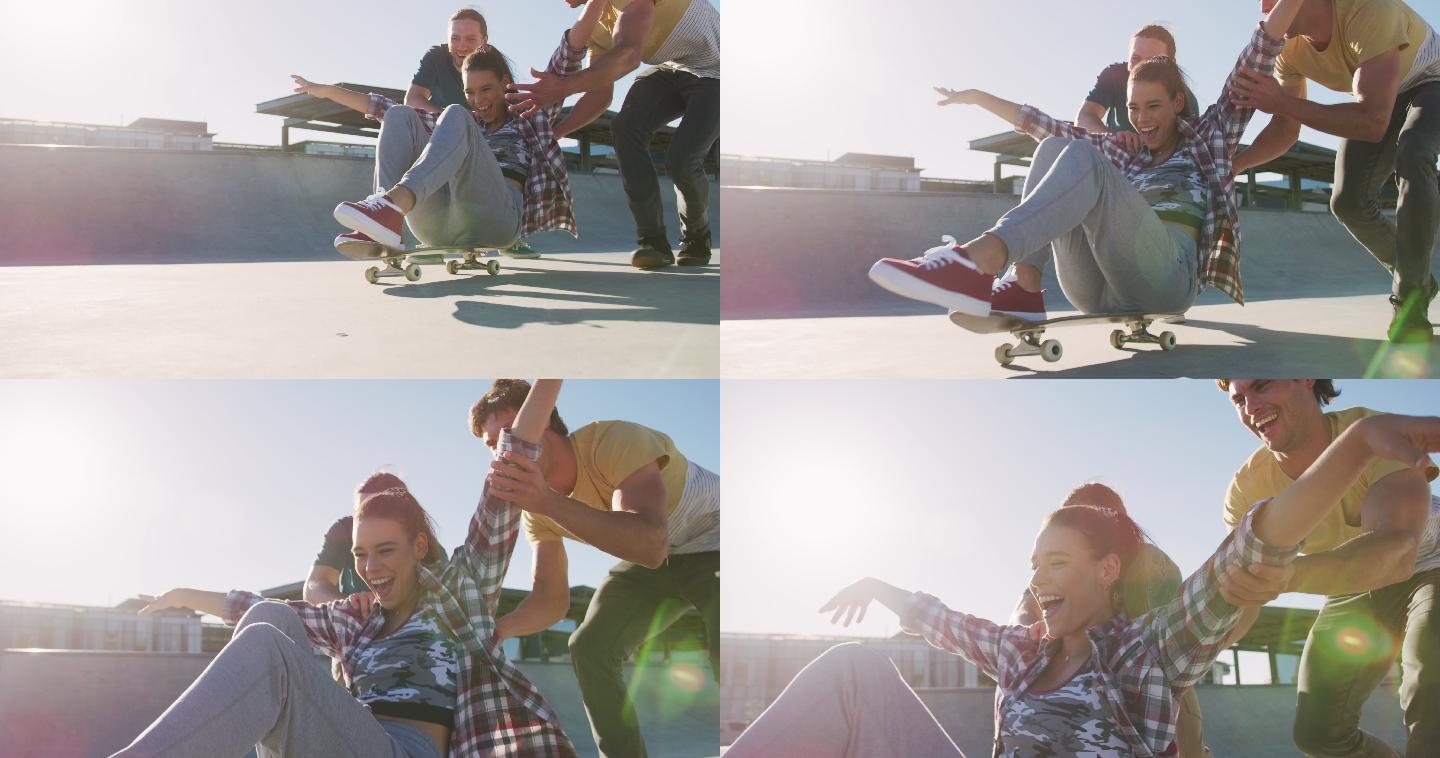 笑着的白种女人和两个男朋友，在阳光明媚的日子玩滑板