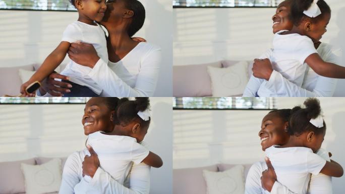 快乐的非裔美国母亲和女儿坐在床上拥抱