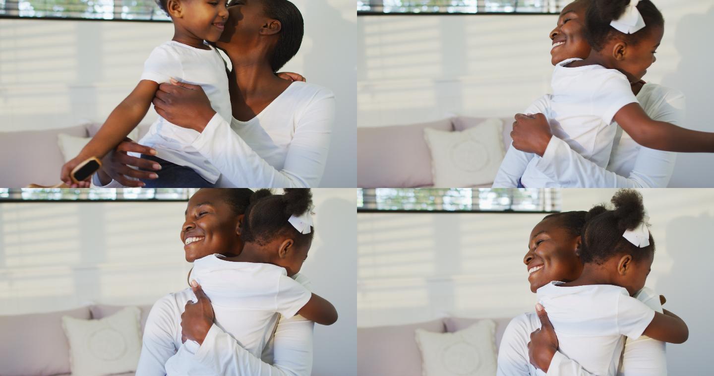 快乐的非裔美国母亲和女儿坐在床上拥抱