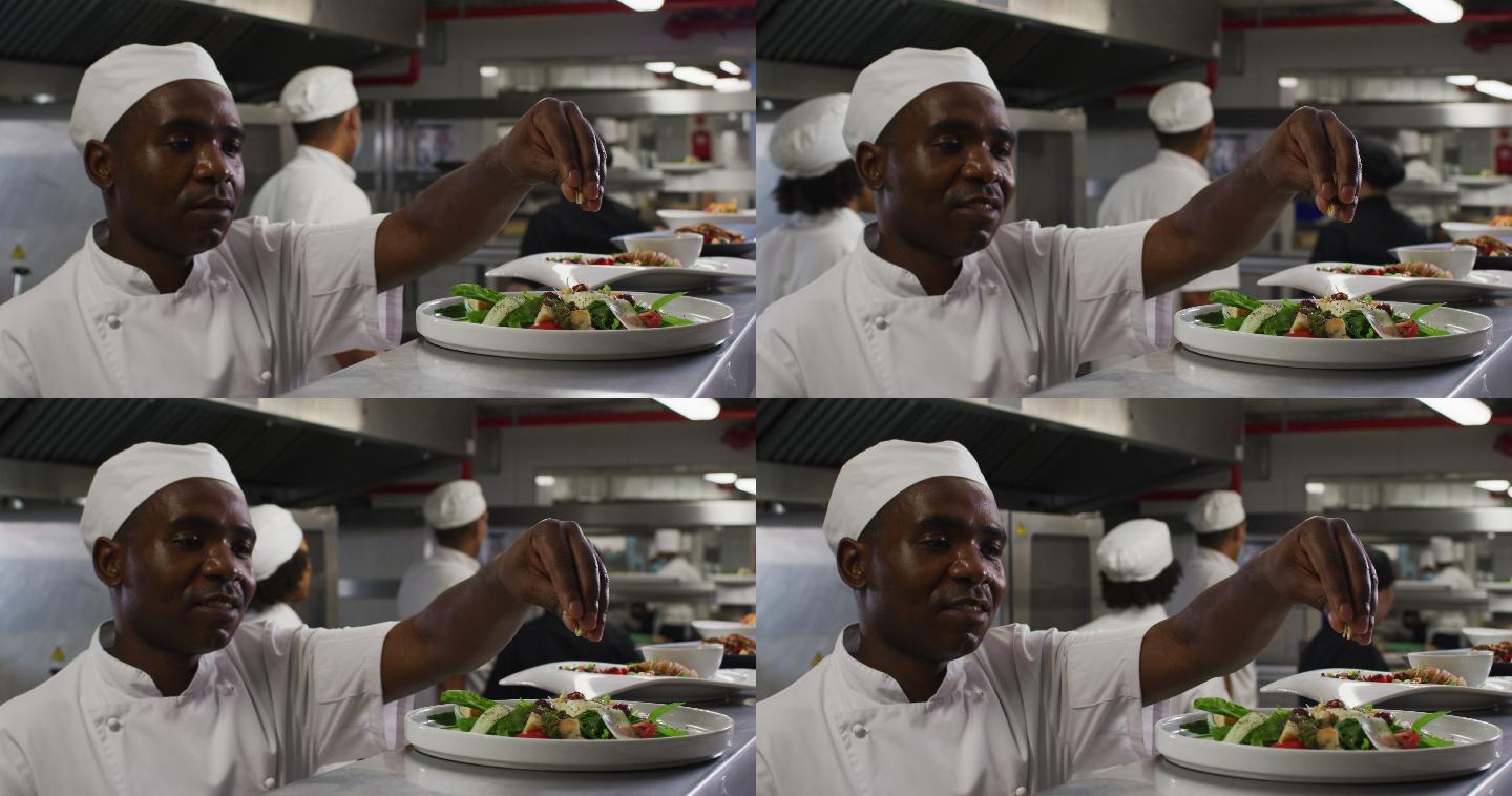 非裔美国男厨师在餐厅厨房装饰菜肴和微笑